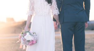 未来へ向かって手を握り歩き出す新婚夫婦のウェディング画像