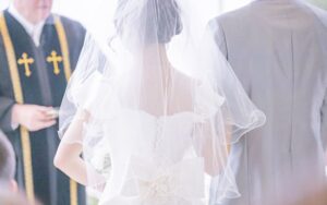 牧師の前で誓いの言葉を述べる花嫁、新郎と教会式の結婚式の写真