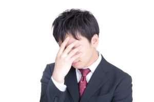 手で顔を覆う男性画像