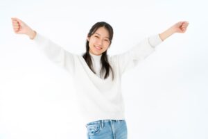 両手を挙げて喜ぶ女性のポーズ画像