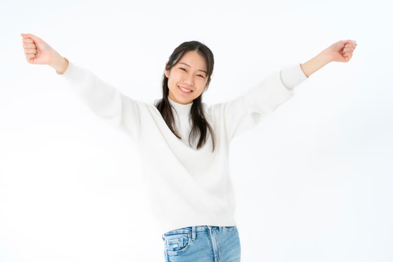 両手を挙げて喜ぶ女性のポーズ画像